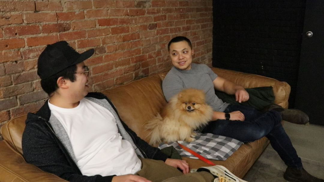 Derek Chung(left) sits beside Trevor Xue(right) with Derek's dog Rex sitting between them. They both sit inside RoamCoffee discussing their day to day lives while drinking their coffee. Photo credit: Branden Rushton